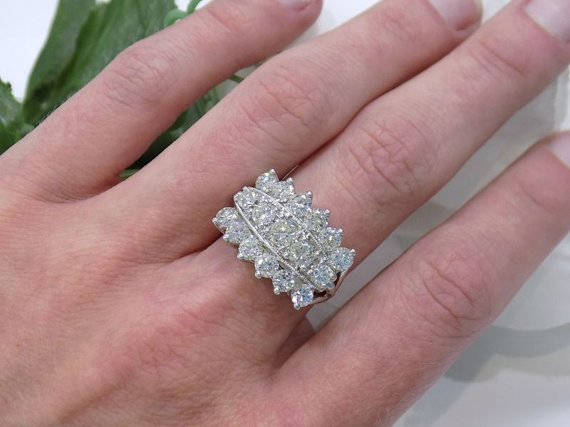 Hand wearing a large diamond cluster ring