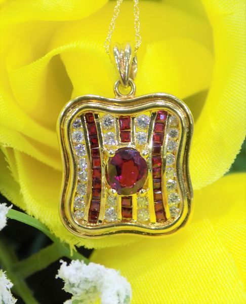 Gold pendant with red and white gemstones, set against a yellow flower
