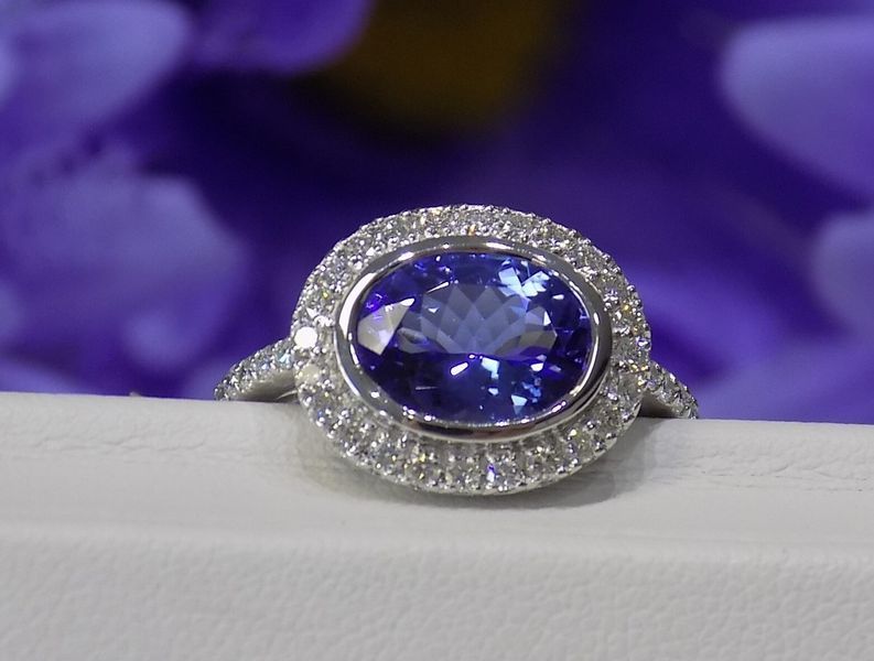 Oval-cut tanzanite ring with a diamond halo