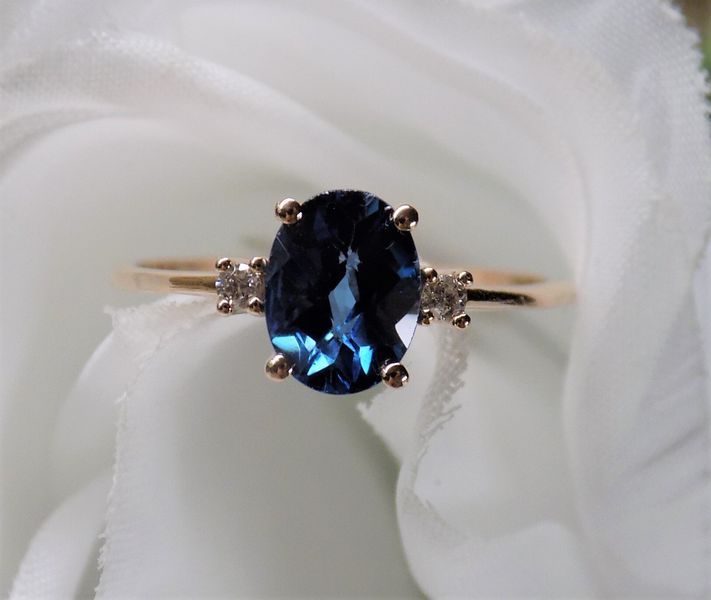 Gold ring with a large oval blue gemstone