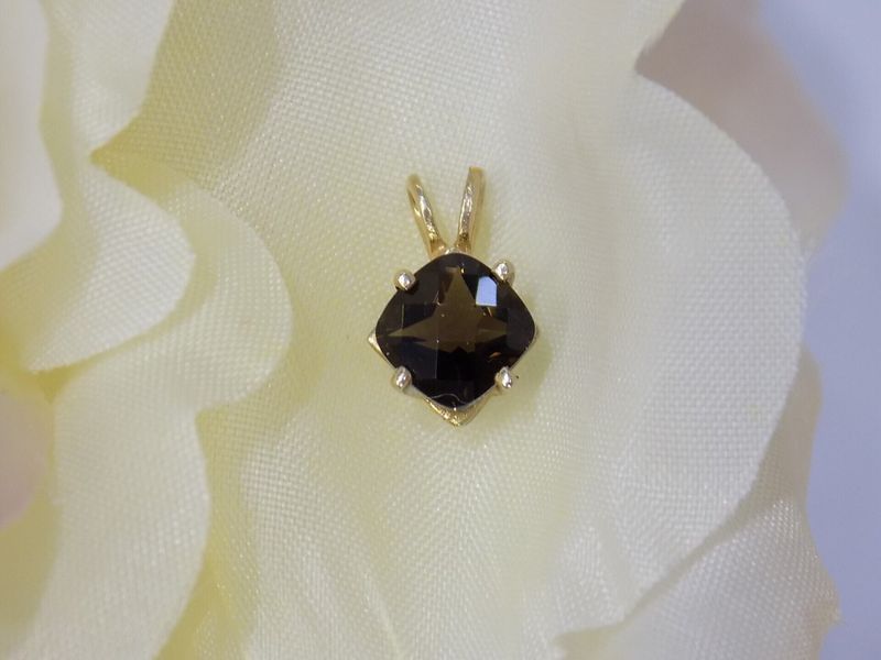 Gold pendant with dark, cushion-cut gemstone