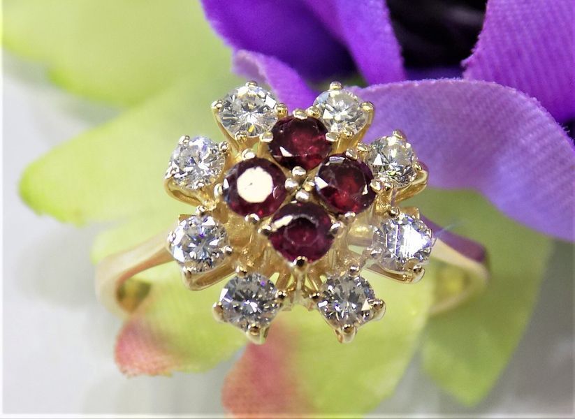 Gold ring with a flower-shaped cluster of white diamonds and red rubies