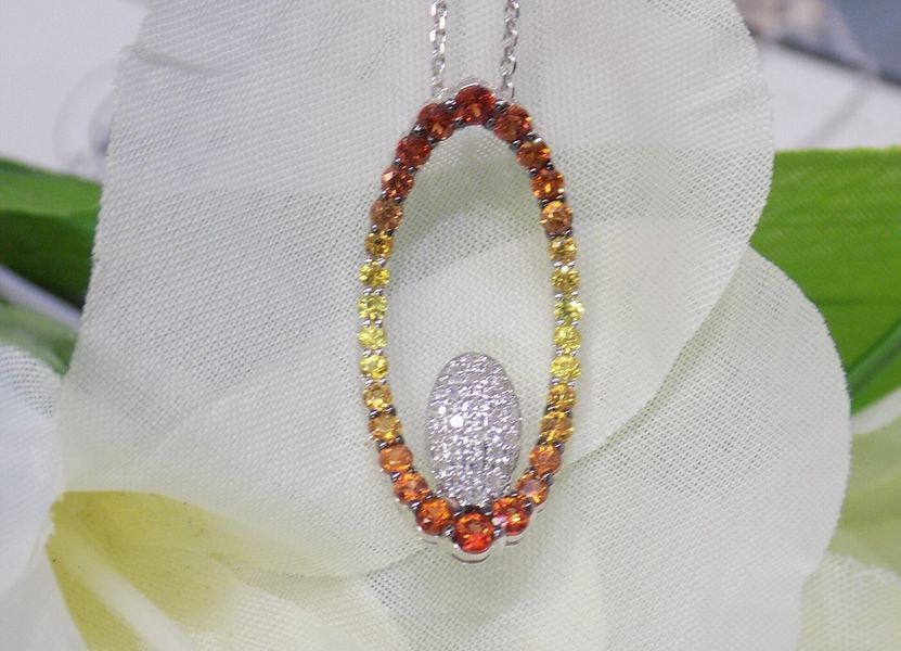 Oval pendant necklace with orange to yellow gemstones and diamond center