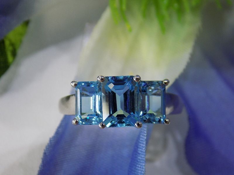 Three blue topaz emerald-cut gemstones