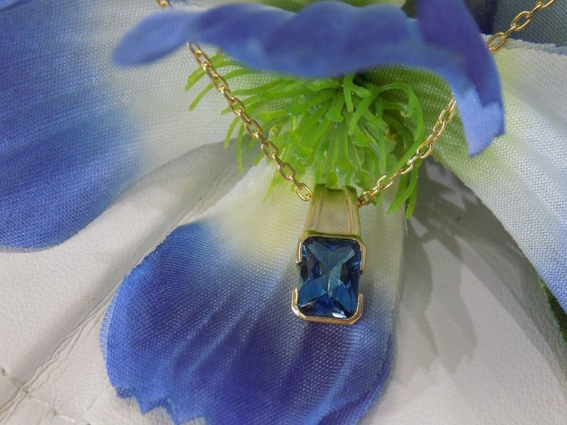 Gold necklace with a rectangular blue gemstone pendant