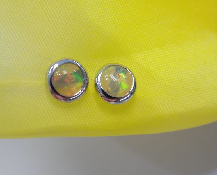 Two opal stud earrings with a silver bezel