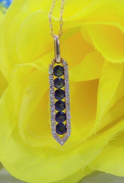 Gold pendant with six blue gems surrounded by diamonds,