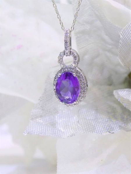 Amethyst pendant necklace with diamond halo on white background