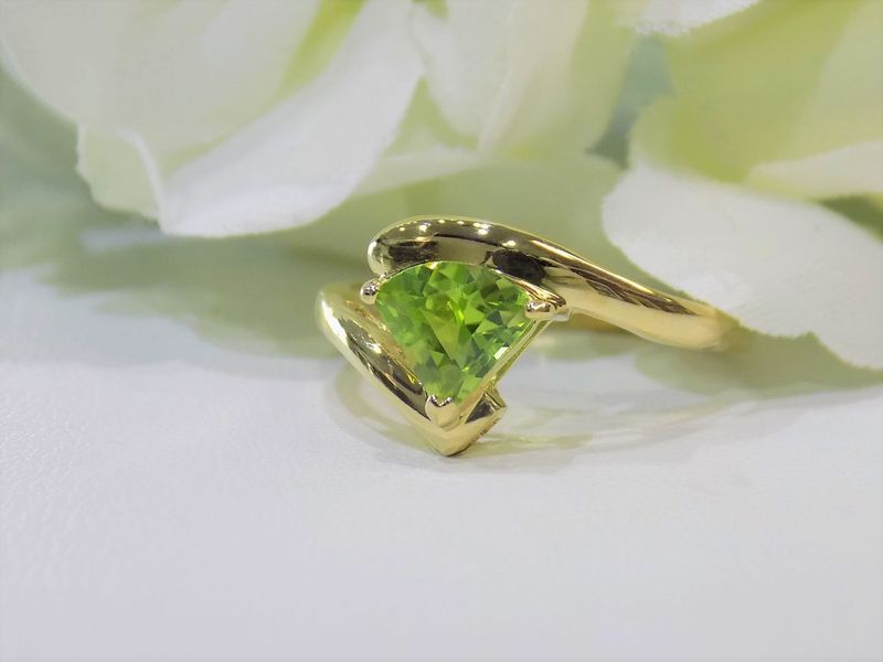 Gold ring with pear-shaped, lime-green gemstone