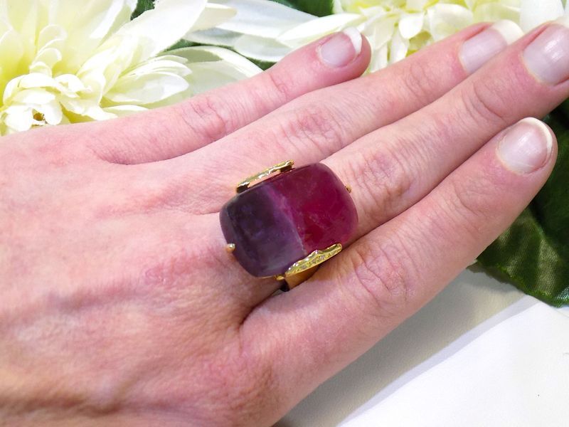 Hand wearing a large gold ring with a rectangular