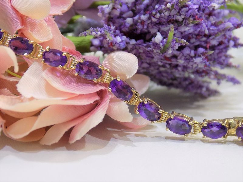 Gold bracelet with oval purple gemstones
