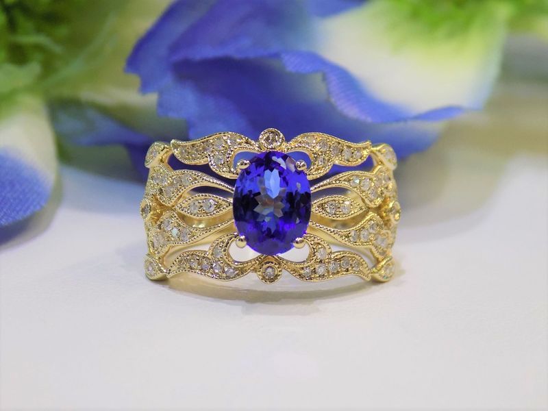 Gold ring with oval blue gemstone and diamond details