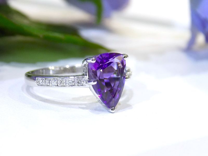 White gold ring with pear-shaped amethyst gemstone. Small diamonds on the band.