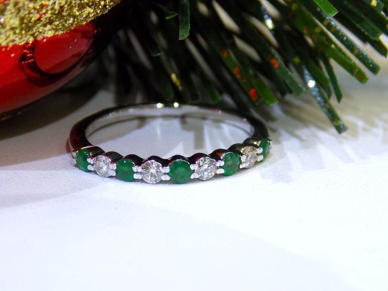 Emerald and diamond ring on a white surface