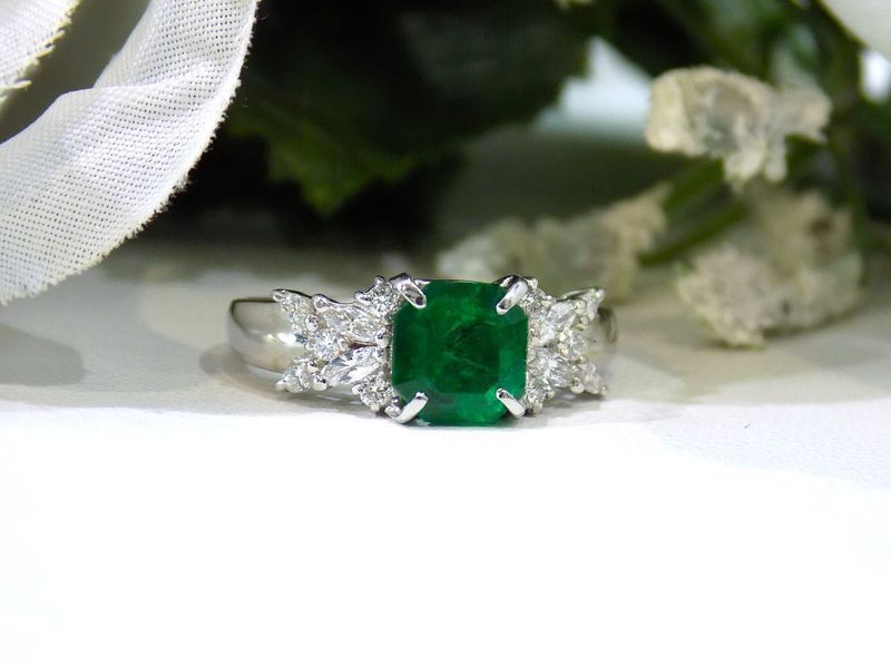 Emerald ring with diamonds on a white background
