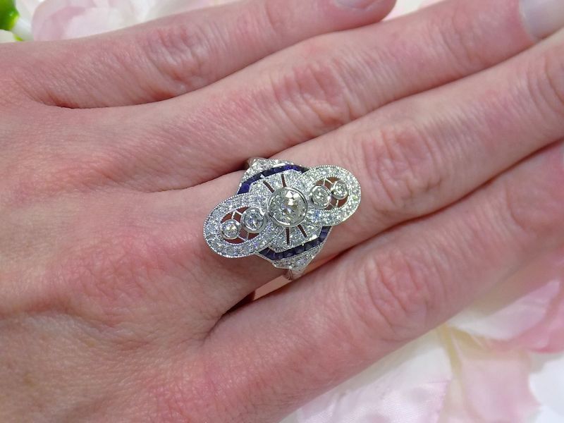 Diamond and sapphire art deco ring on a hand