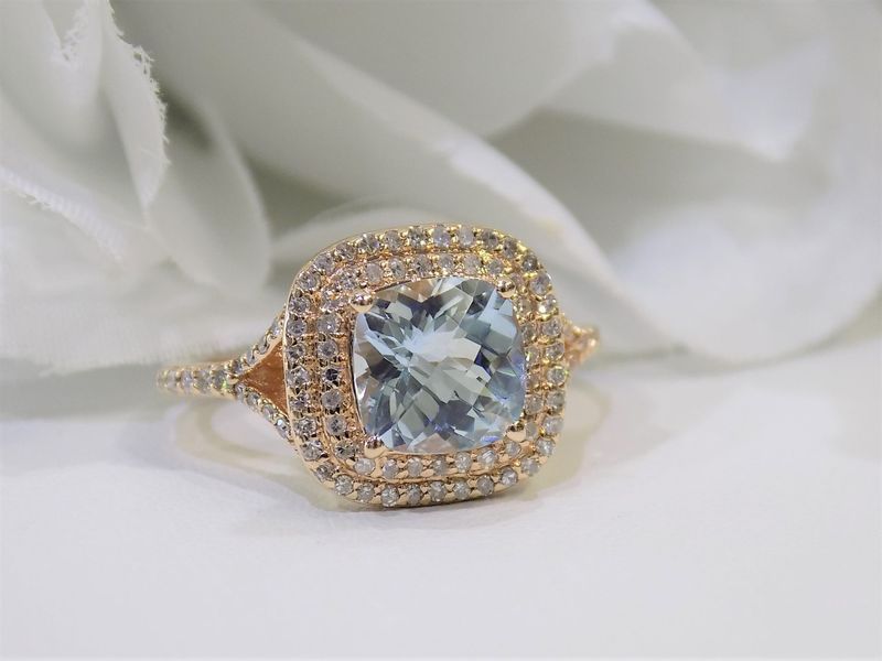Rose gold ring with a square aquamarine center stone and diamond halo