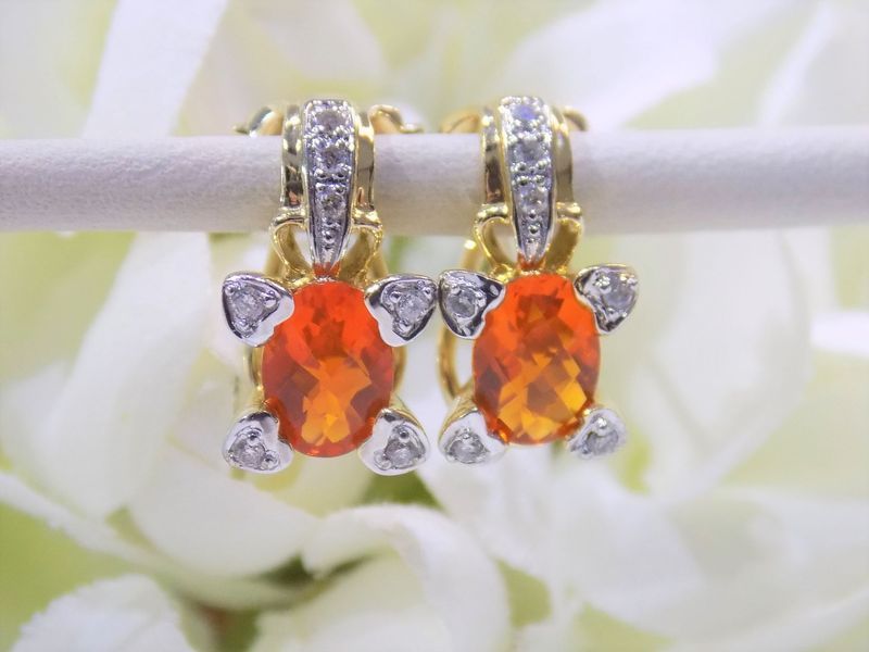 Gold earrings with oval orange gemstones and small diamond accents