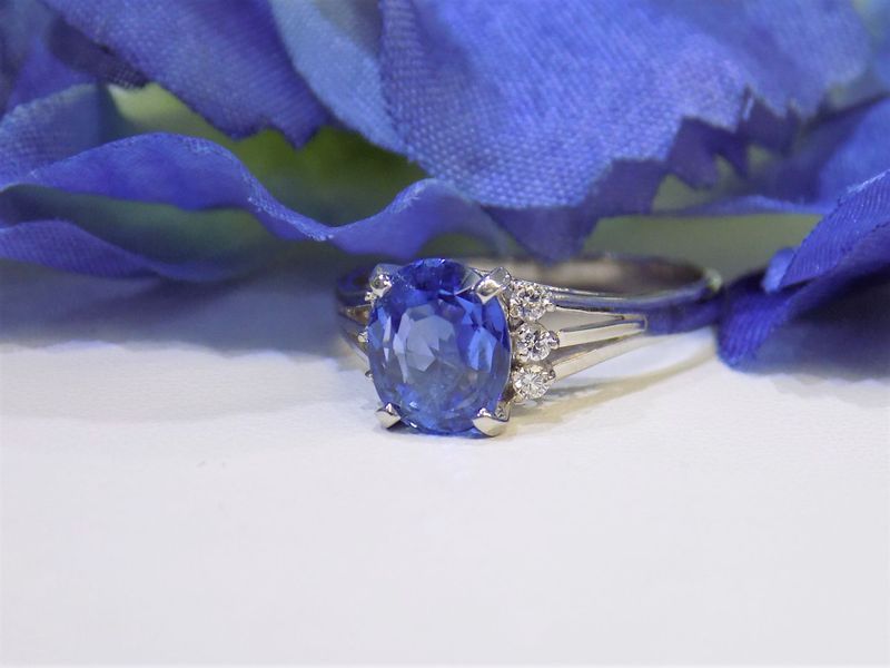 Blue sapphire engagement ring with small diamonds on a blue flower background