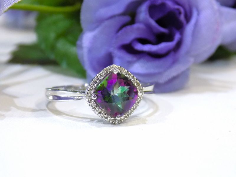 Ring with a large, iridescent gemstone, surrounded by small diamonds