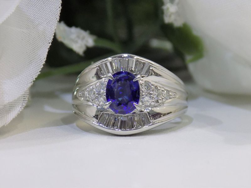 Oval sapphire ring set with baguette and round diamonds on a white background
