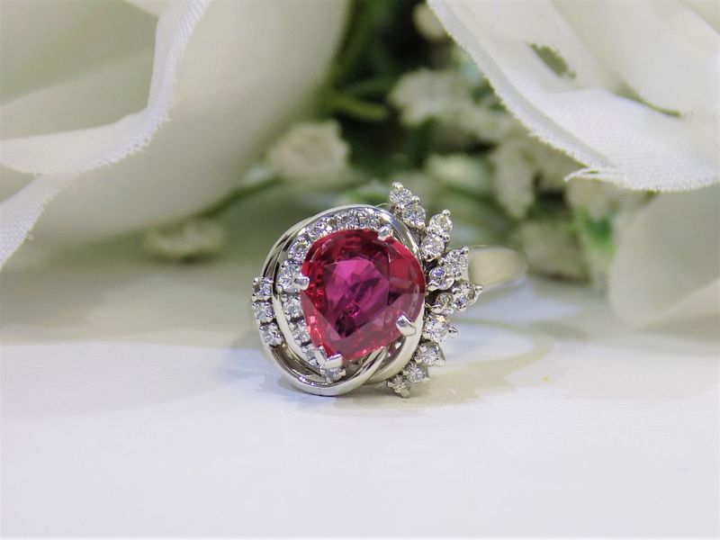 Ring with a pear-shaped red stone surrounded by small white stones
