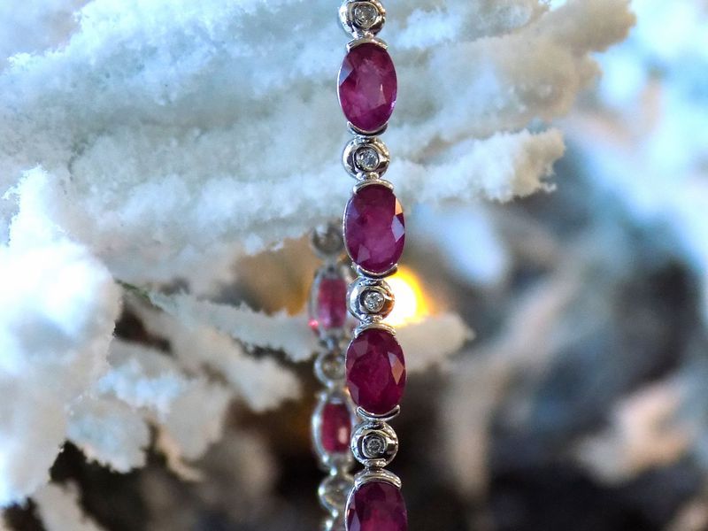 Ruby and diamond bracelet draped on a snow-covered branch