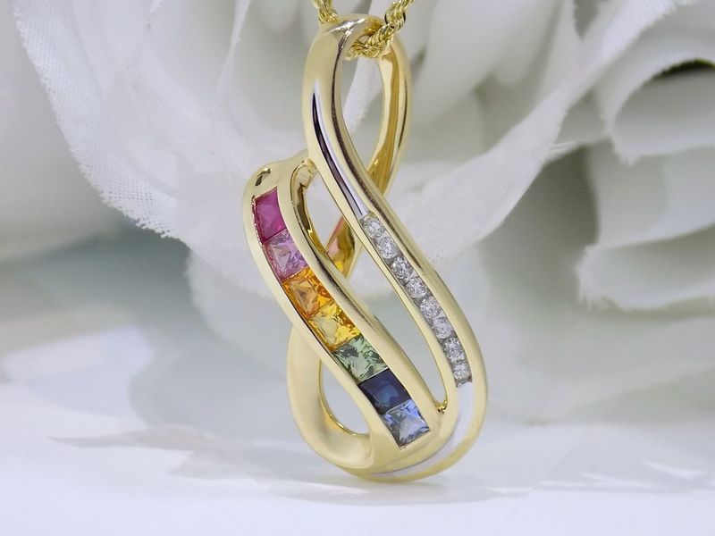 Gold infinity pendant with rainbow gemstones and diamonds on a gold chain