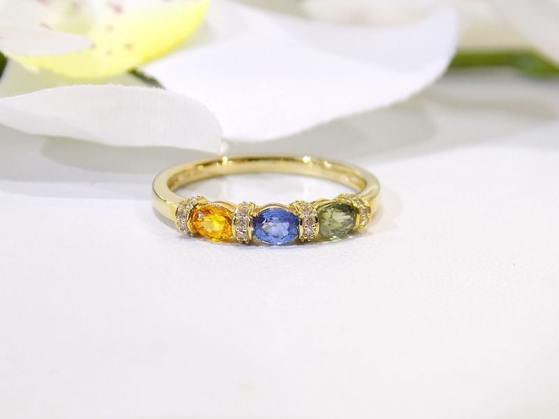 Gold ring with yellow, blue, and green gemstones
