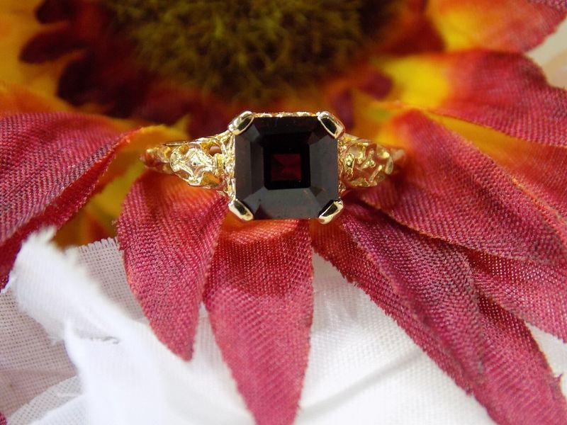 Gold ring with a large, square, dark red gemstone
