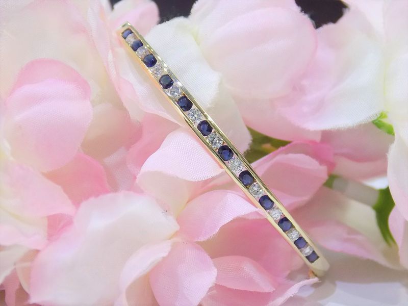 Gold bangle bracelet with alternating blue sapphires 