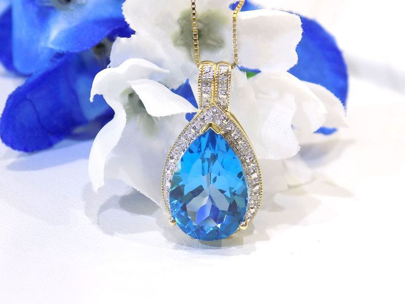 Gold pendant with a pear-shaped blue gemstone