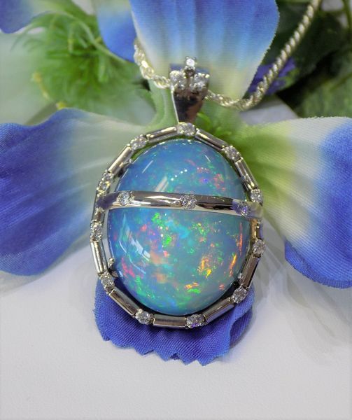 Blue opal pendant necklace with white gold setting on a blue flower
