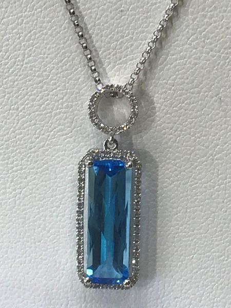 Blue gemstone pendant necklace with diamond accents on a white background.