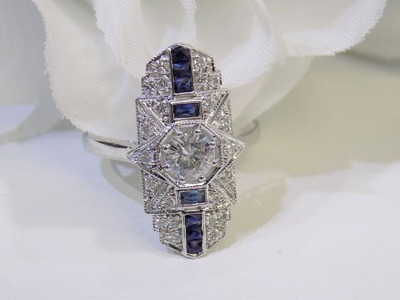 Art Deco diamond and sapphire ring on a white background