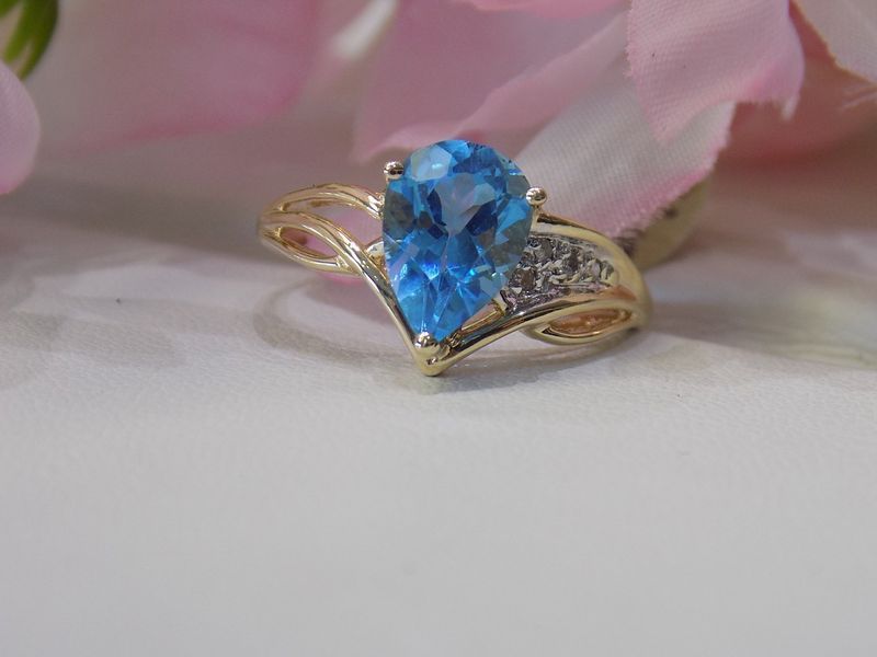 Gold ring with pear-shaped blue gemstone and small diamonds