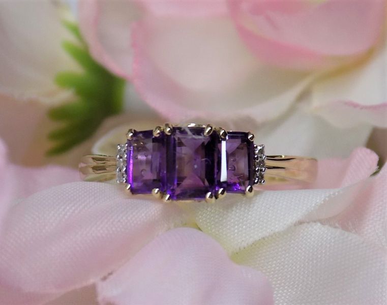 Gold ring with three rectangular amethyst stones, set on pink flowers