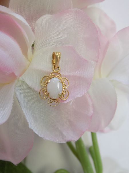 Gold pendant with a white stone