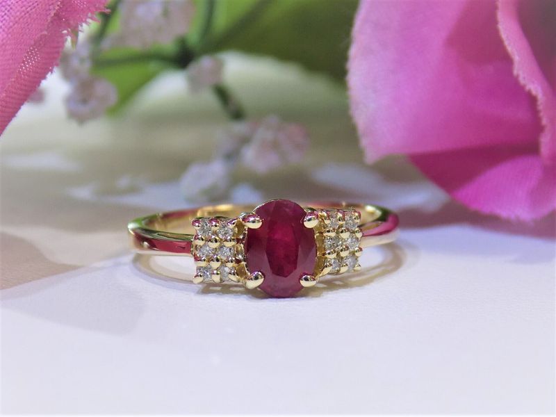 Gold ring with oval ruby center stone and diamond accents