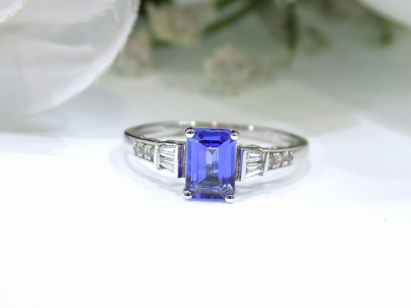 Silver ring with a rectangular blue gemstone and small diamond accents