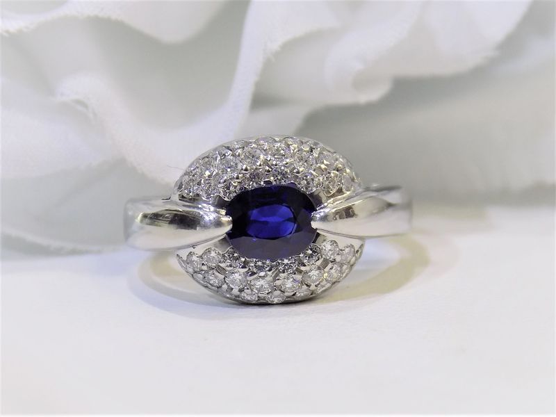 A sapphire ring with a cluster of diamonds set in white gold