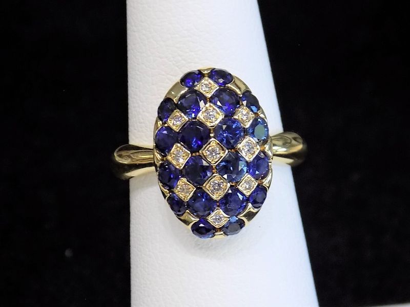 Gold ring with an oval-shaped cluster of blue sapphires and diamonds 