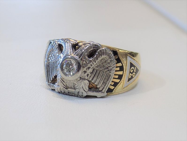 A gold ring with a double-headed eagle and diamond center