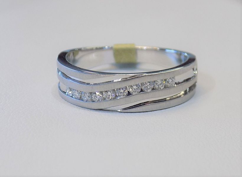 Silver ring with a row of diamonds set in a wavy design