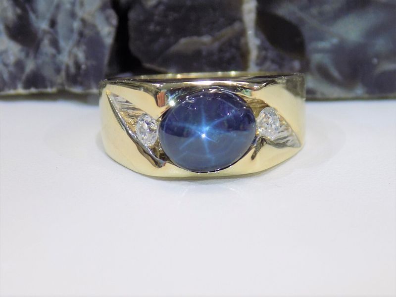 Gold ring with a blue star sapphire and two small diamonds