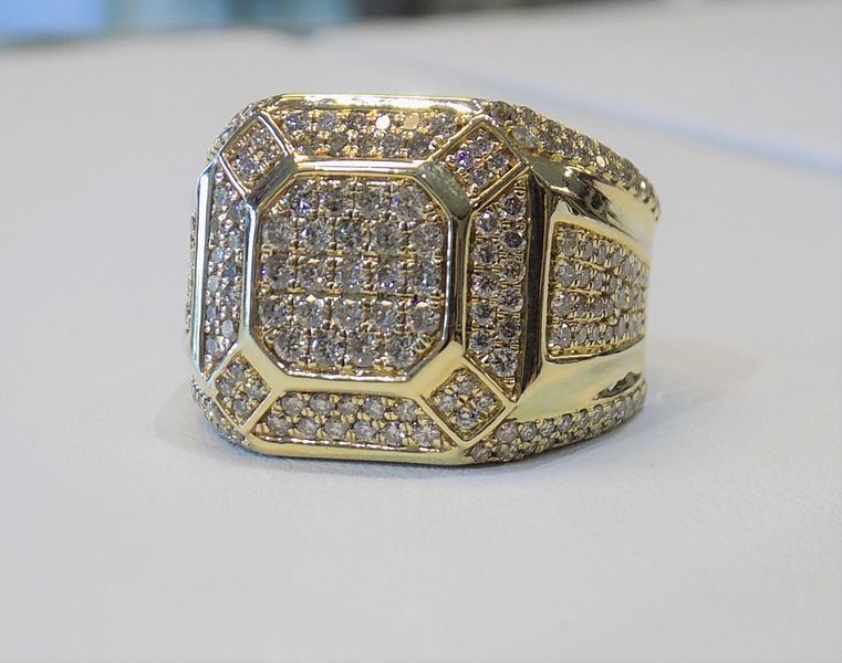 Gold ring encrusted with numerous small diamonds on a white surface