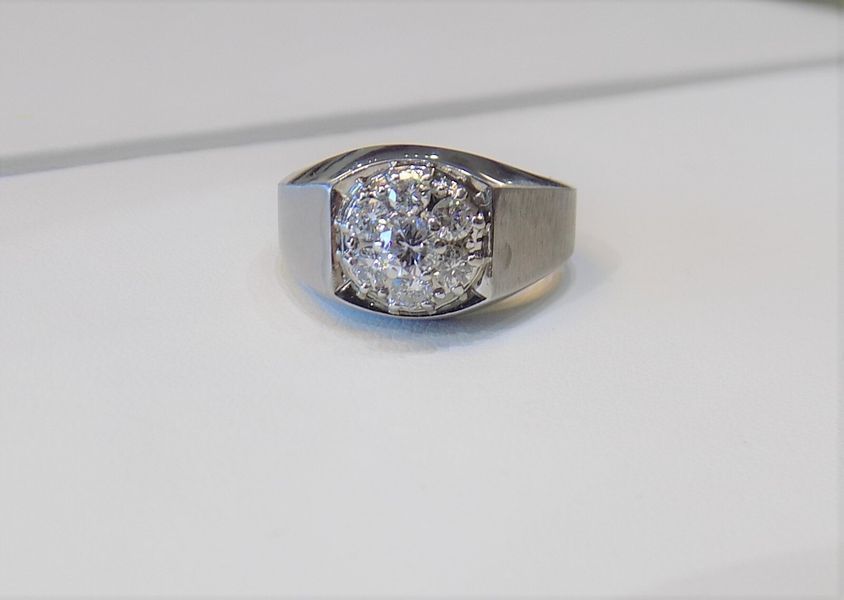 Silver ring with a cluster of clear stones on a white surface