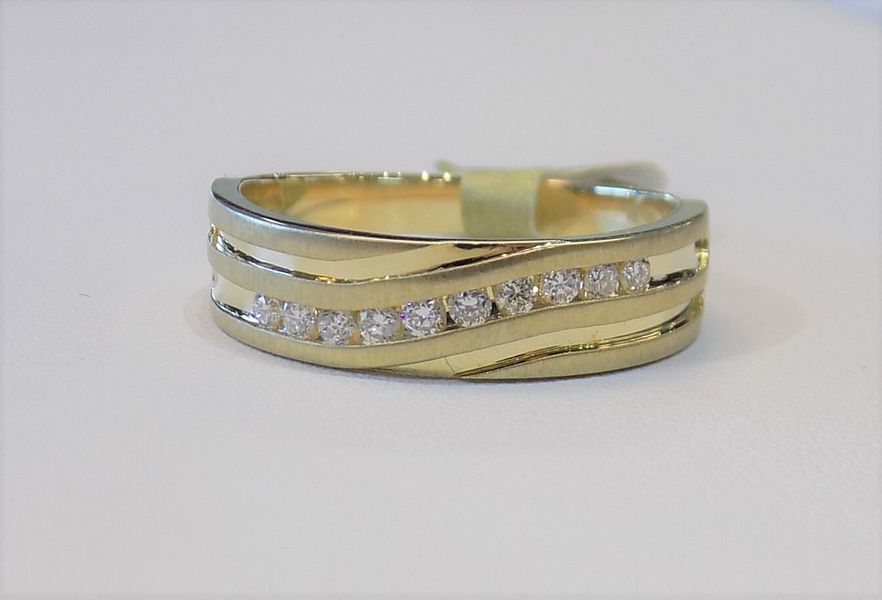 Gold ring with a row of diamonds on a white surface
