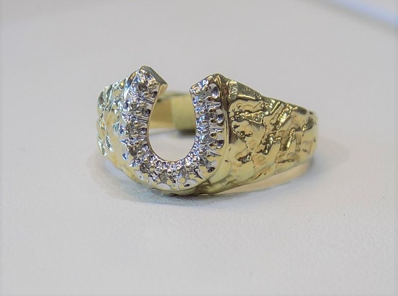 Gold horseshoe ring with embedded diamonds
