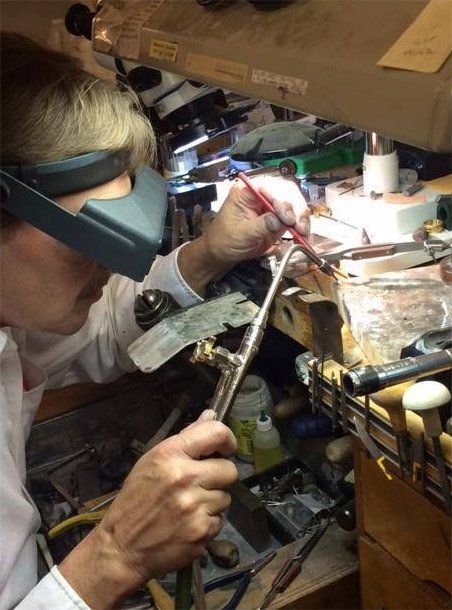 Jeweler soldering metal with a torch